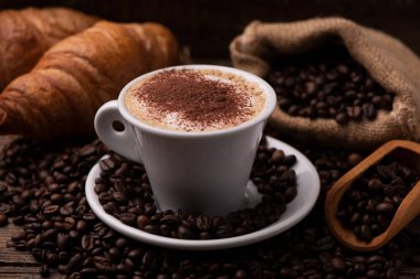 cappuccino ve kruvasan kahve çekirdekleri ile
