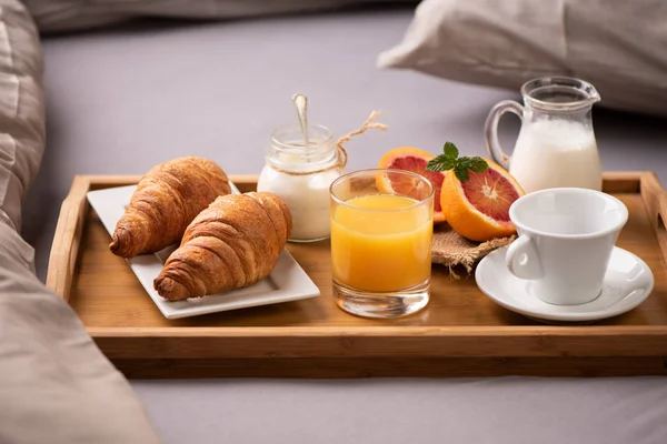 Kontinentális reggeli. Reggeli tálca az ágyon, kávé, narancs — Stock Fotó