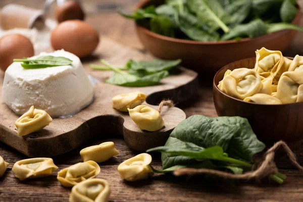 Fesh tortellini ravioli on wooden rustic table with spinach and — 스톡 사진