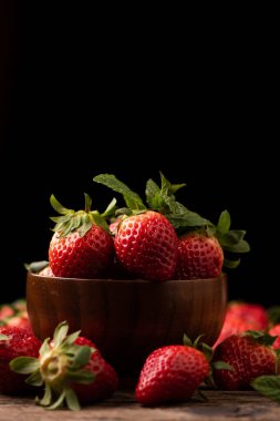 Tahta kırsal masada sepette taze çilek, yakın plan.