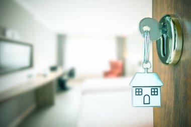 Ev anahtarı ve kapı deliğinde anahtarlık. Yeni ev kavramı satın al