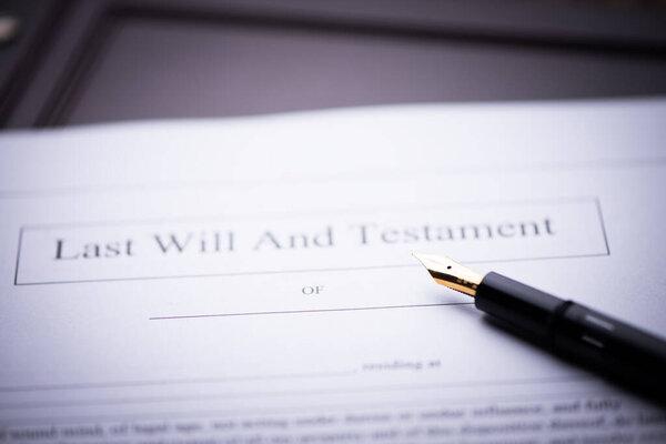 Last Will and testament document on wooden table close up