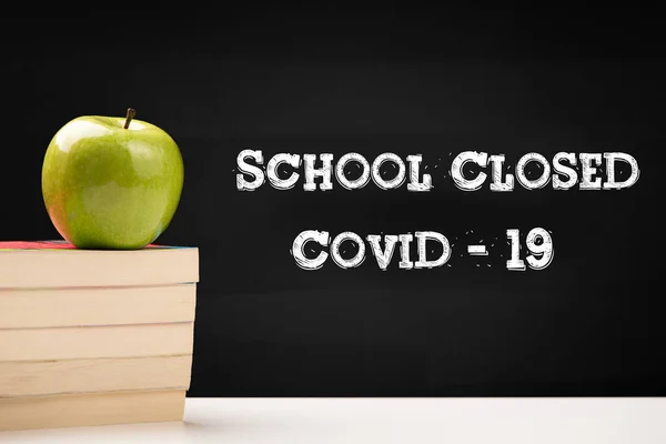 School Closed COVID-19 text written on blackboard  close up