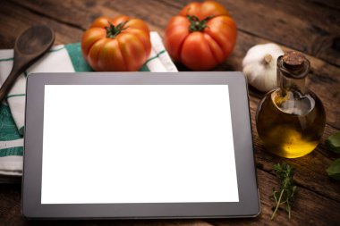 Mutfak aletleri ve malzemelerle dolu tablet yukarıdan görünüyor. Kapat.