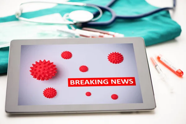 White health center desk with tablet with coronavirus title and medical and office supplies. Close up