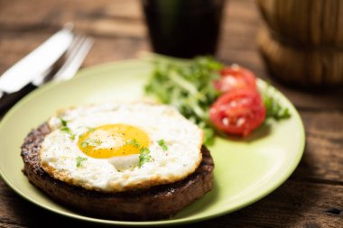 Yumurta kapaklı leziz bir hamburger.