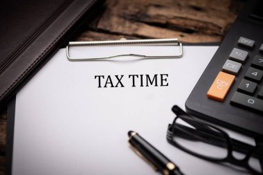 Tax Time text on Document and gavel isolated on wooden office desk close up clipart