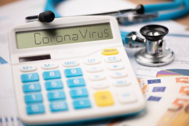 Coronavirus salgını ve maddi sonuçları. CORONAVIRUS sözcüğüne sahip bir hesap makinesi kapat