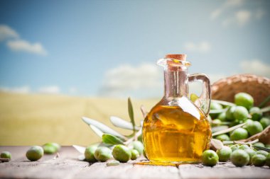 Ahşap masada zeytin yağı ve zeytin dalı var. Yaklaş.