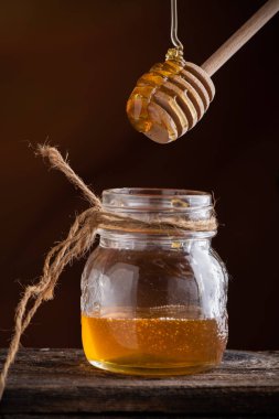 Bal çiseleme. Bir çömleğin bal servisi yakın çekim.
