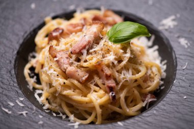 Siyah tabakta spagetti carbonara yakın plan.
