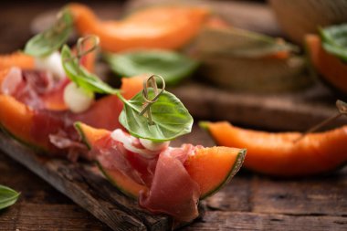 Parma jambonlu, fesleğenli ve vişneli tatlı su kavununu kapat.