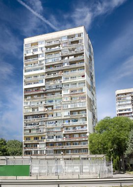 Mavi gökyüzü ve bulutlu arka planı olan eski apartman.