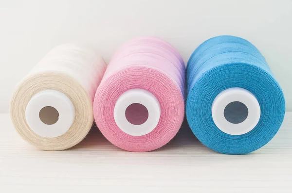 Hilo de coser azul rosa beige están en la mesa —  Fotos de Stock