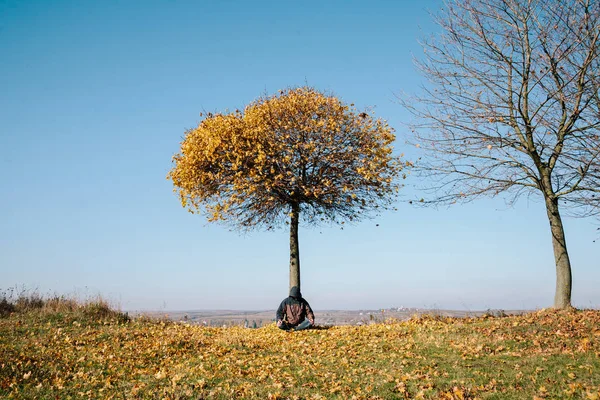 El hombre medita bajo el árbol de otoño — Foto de Stock