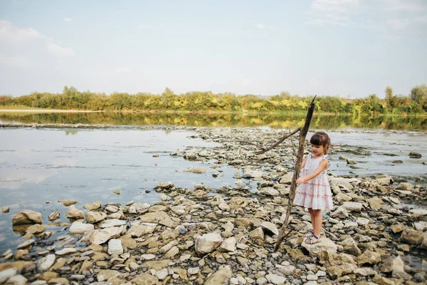Девушка, держащая сухую ветку реки — стоковое фото