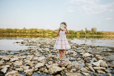 Nehrin kuru bir taş tutan kız