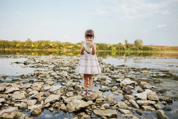 Девушка, держащая сухой камень реки — стоковое фото