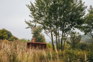 bir bebek ile küçük kız ormanda eski römork üzerinde duruyor