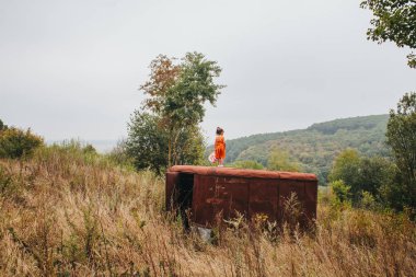 bir bebek ile küçük kız ormanda eski römork üzerinde duruyor