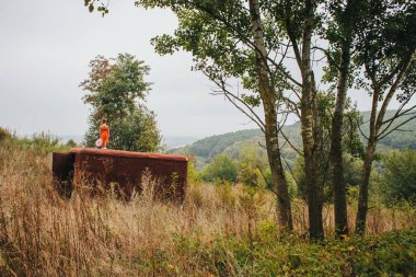 bir bebek ile küçük kız ormanda eski römork üzerinde duruyor