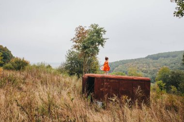 bir bebek ile küçük kız ormanda eski römork üzerinde duruyor
