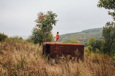 bir bebek ile küçük kız ormanda eski römork üzerinde duruyor