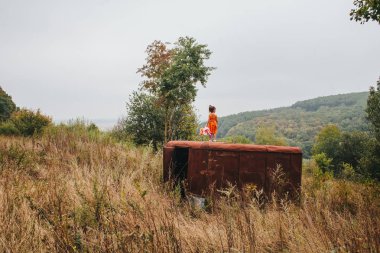 bir bebek ile küçük kız ormanda eski römork üzerinde duruyor
