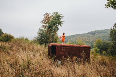 bir bebek ile küçük kız ormanda eski römork üzerinde duruyor