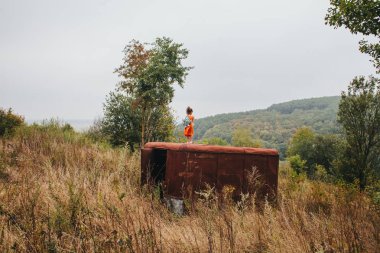 küçük kız ormanda eski römork üzerinde duruyor