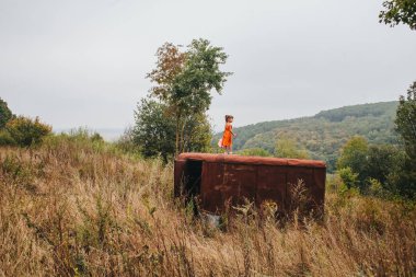 küçük kız ormanda eski römork üzerinde duruyor