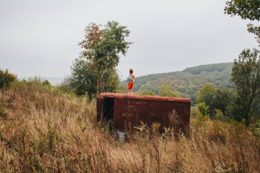 küçük kız ormanda eski römork üzerinde duruyor