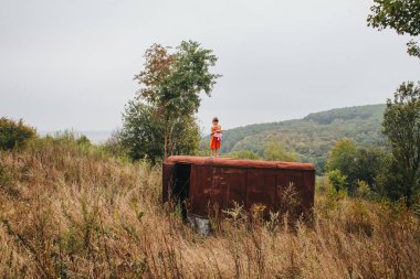 bir bebek ile küçük kız ormanda eski römork üzerinde duruyor