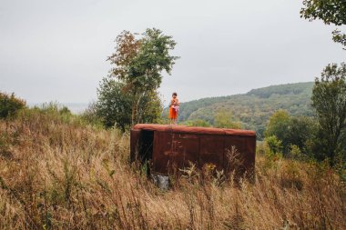 bir bebek ile küçük kız ormanda eski römork üzerinde duruyor