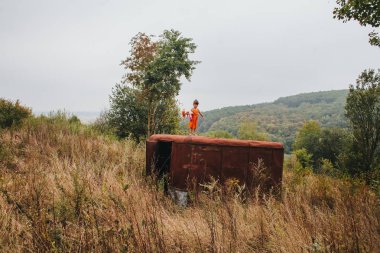 bir bebek ile küçük kız ormanda eski römork üzerinde duruyor