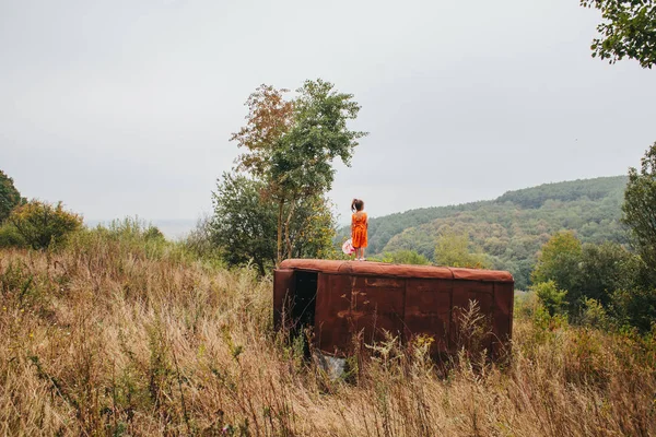 bir bebek ile küçük kız ormanda eski römork üzerinde duruyor