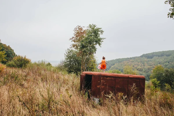 bir bebek ile küçük kız ormanda eski römork üzerinde duruyor