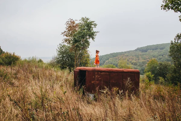 bir bebek ile küçük kız ormanda eski römork üzerinde duruyor