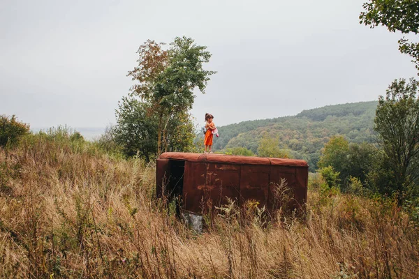 bir bebek ile küçük kız ormanda eski römork üzerinde duruyor