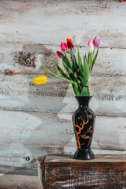 Cam vazo içinde sunulan Lale ile eski ahşap arka plan