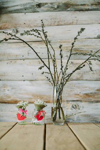 Eski ahşap arka plan ile bir şişe ve willow sutyen kardelen