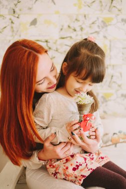 kızı anne çiçek koklama dizlerinin üzerinde oturur