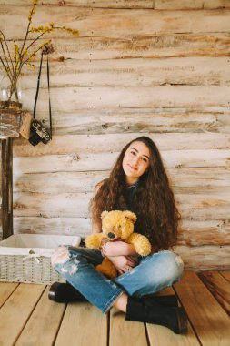 hippi kız ile bir ayı oyuncak ahşap arka plan üzerinde