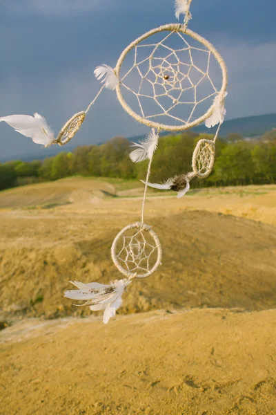 Dreamcatcher hanging from a dry field at sunset. — Stock Photo, Image