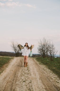 Hippi kız toprak yolda ayakta