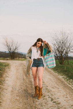 Hippi kız toprak yolda ayakta