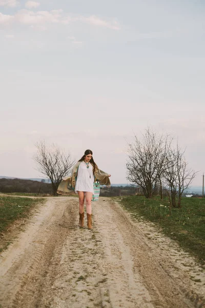 Hipster chica de pie en un camino de tierra — Foto de Stock