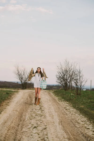 Hipster chica de pie en un camino de tierra — Foto de Stock