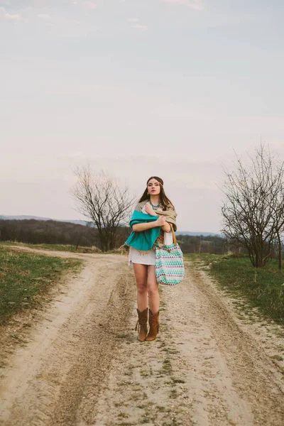 Хипстерская девушка стоит на грунтовой дороге — стоковое фото