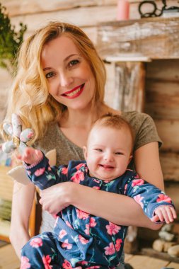 Anne kızı onun kollarında tutar..